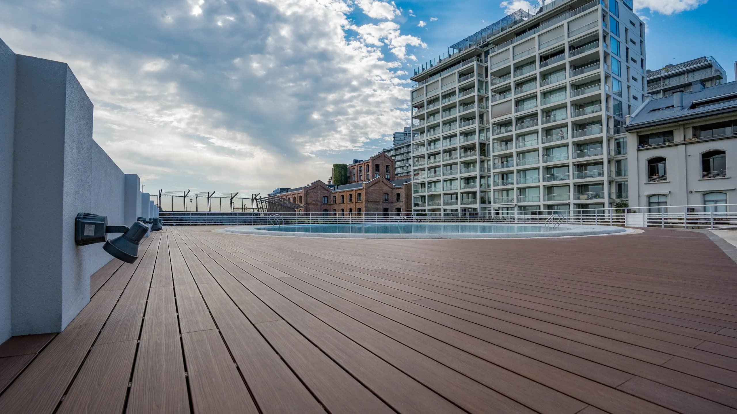 Rooftop with a pool and WPC decking facing apartment buildings
