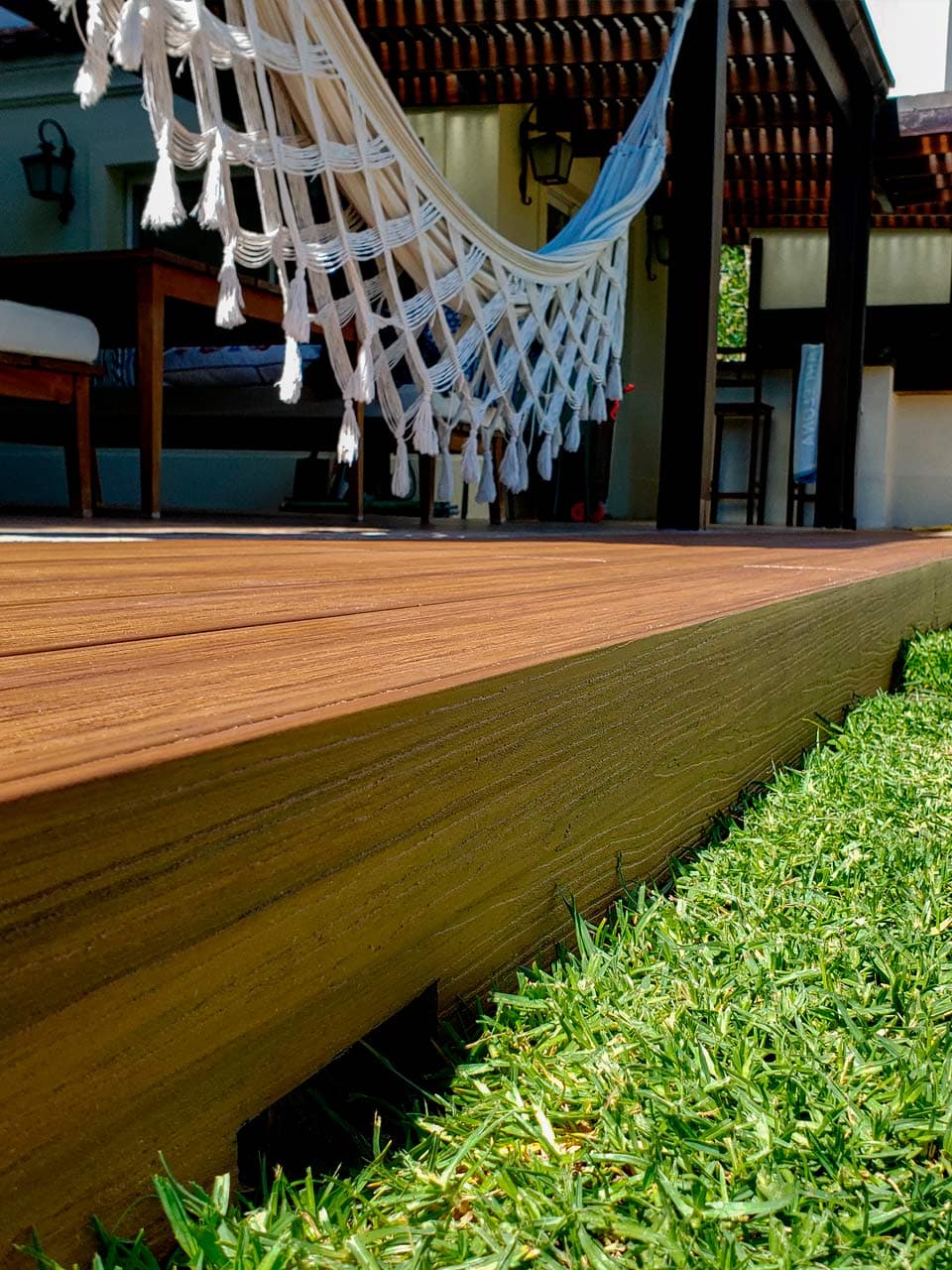 Edge of a WPC deck platform next to the lawn, under a hammock