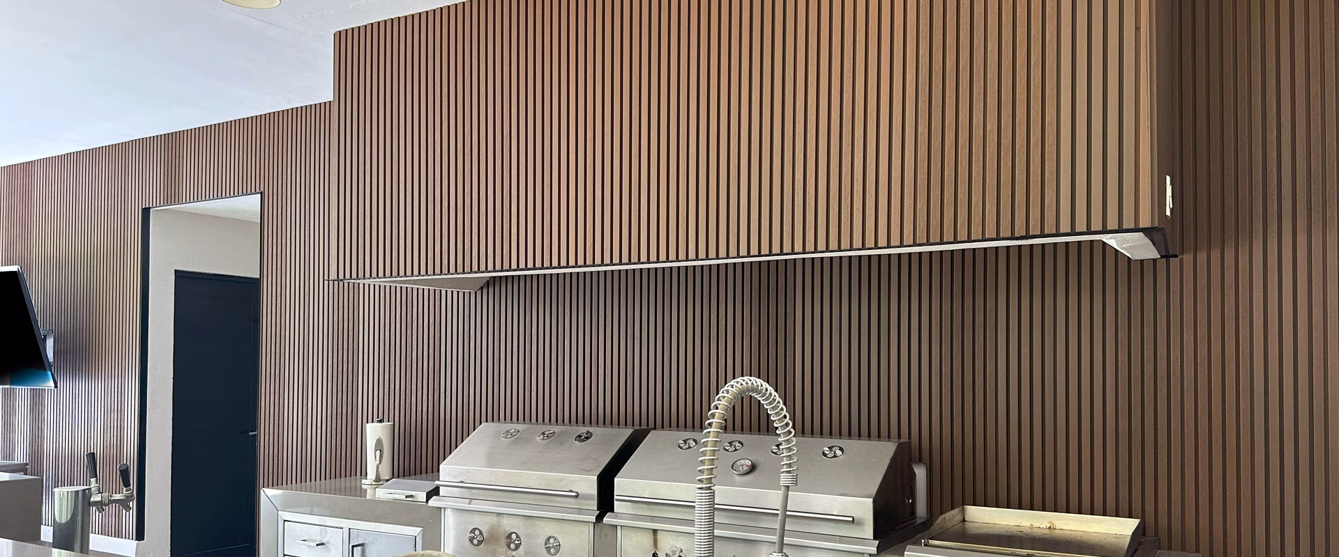 Close-up of a WPC grooved panel wall in an outdoor kitchen