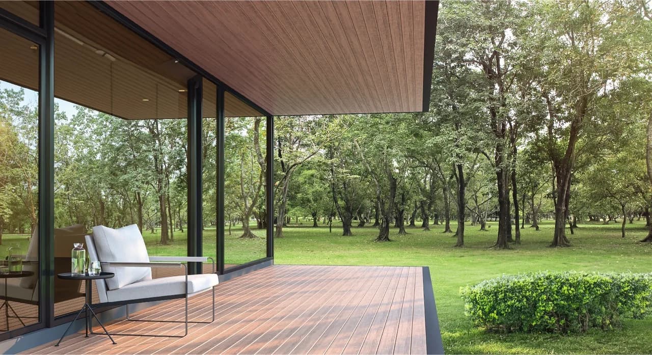 Covered patio with a wood-tone WPC cladding ceiling over a deck, facing a wooded garden