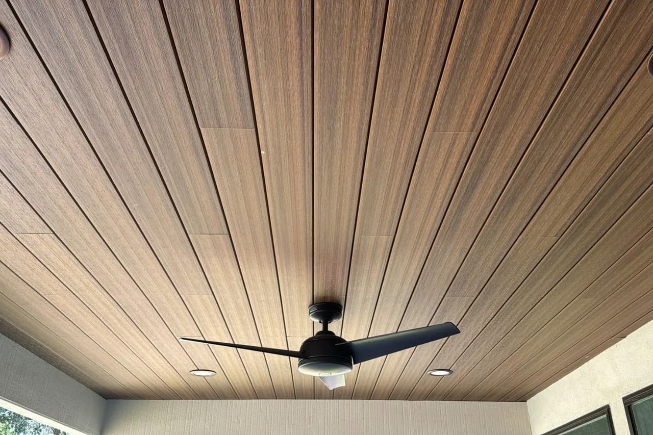 Wood-tone WPC cladding ceiling with a ceiling fan