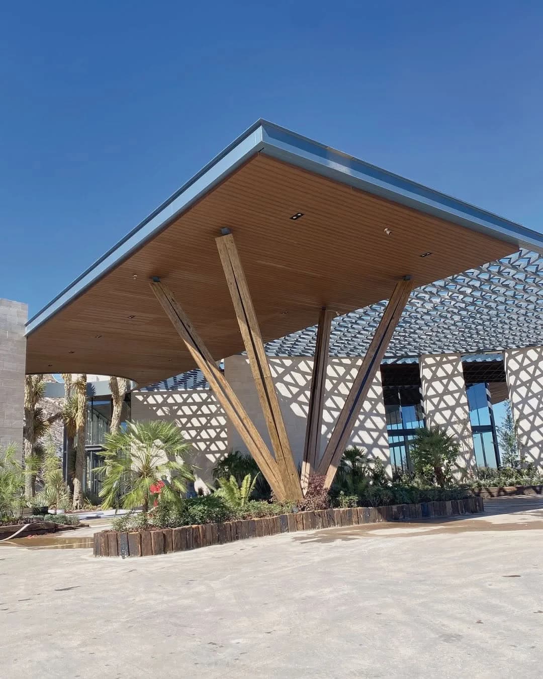 Techumbre de acceso de un parque público con plafón de listones de WPC y celosía