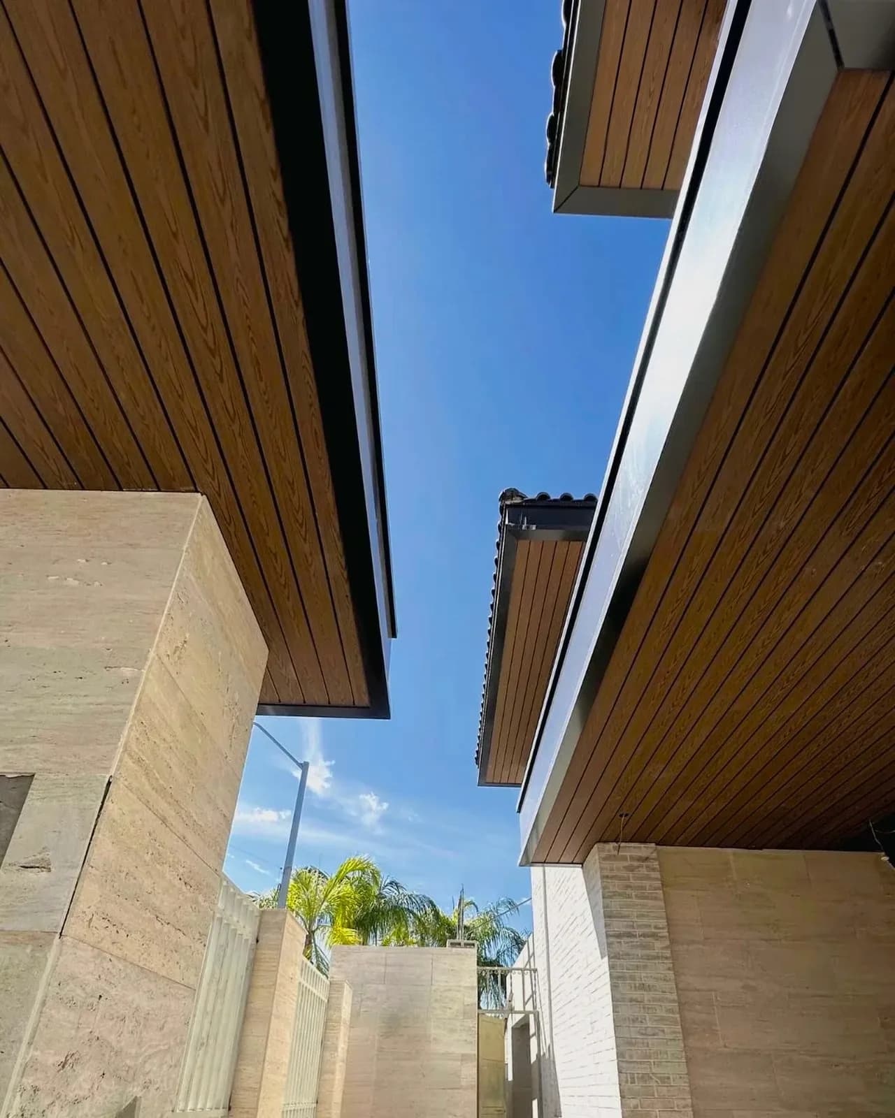 Facade overhangs clad in WPC boards against a blue sky