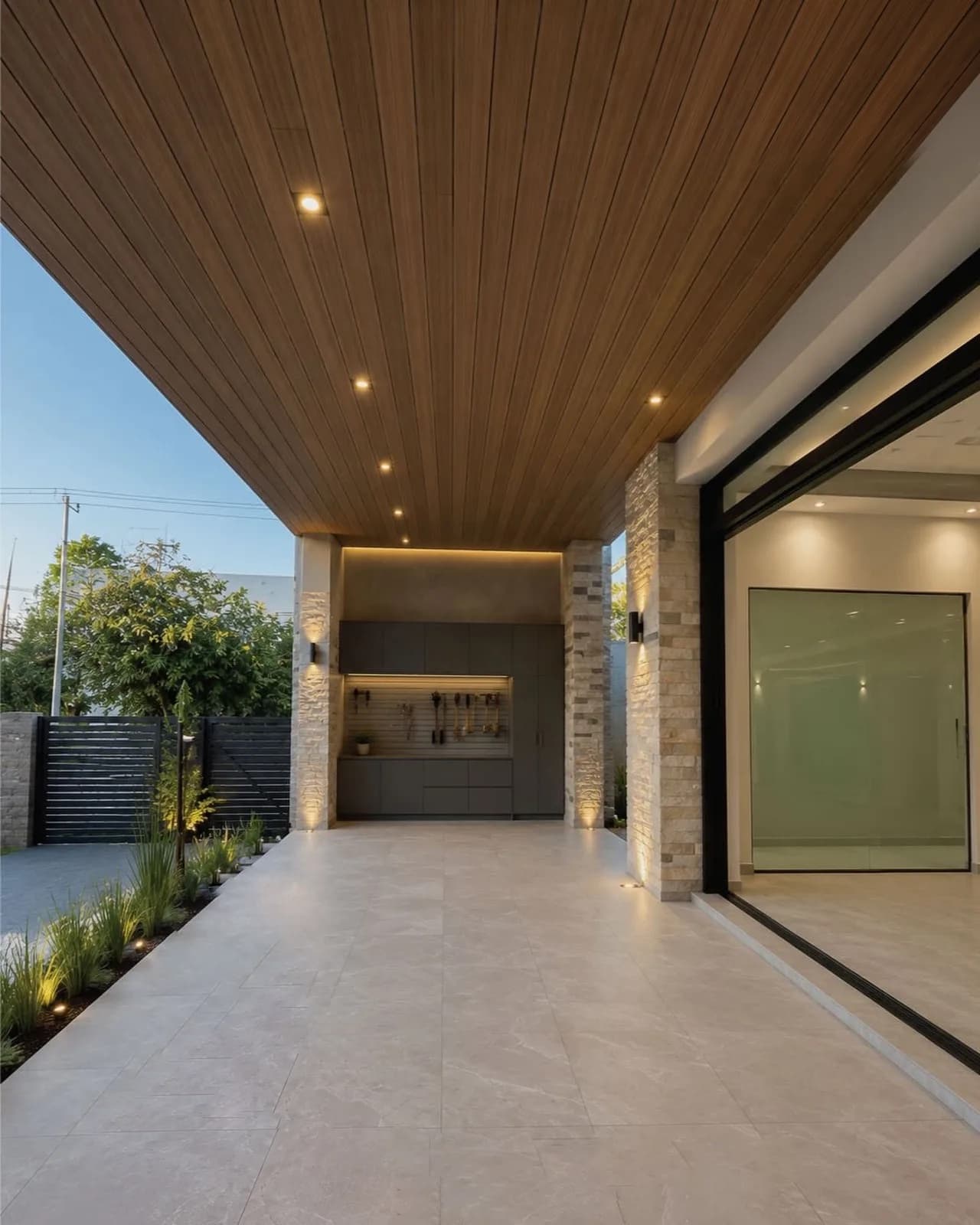 Covered terrace of a house with a WPC board ceiling, stone columns and large windows