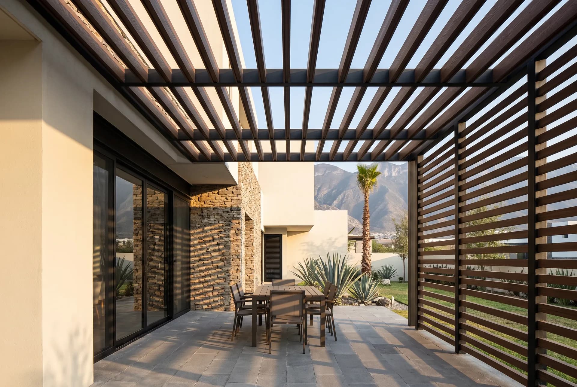 IPE WPC beam pergola and privacy screen on the patio of a house, with outdoor dining and mountains in the background