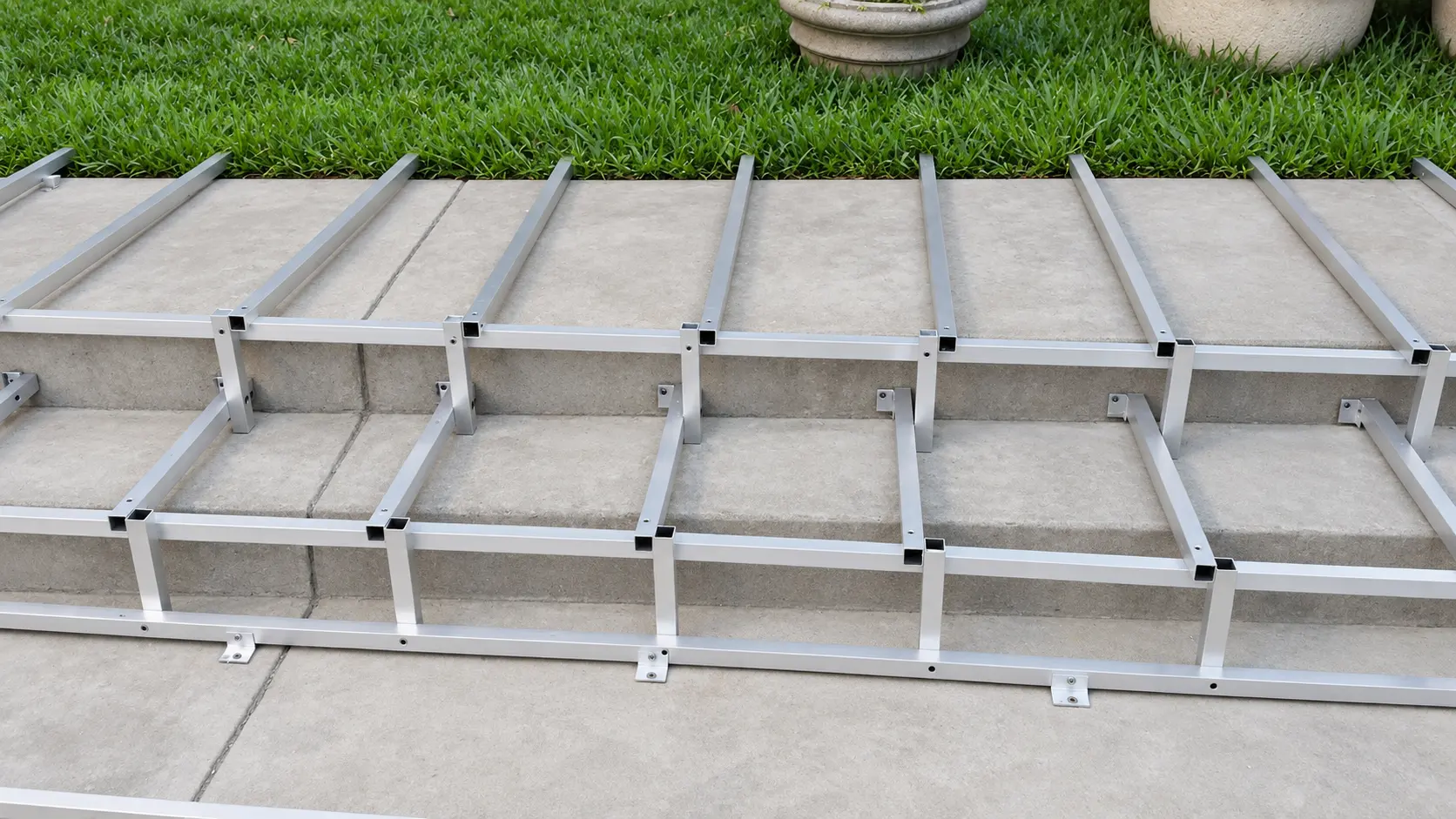 Bastidor de aluminio armado para unos escalones, junto al pasto