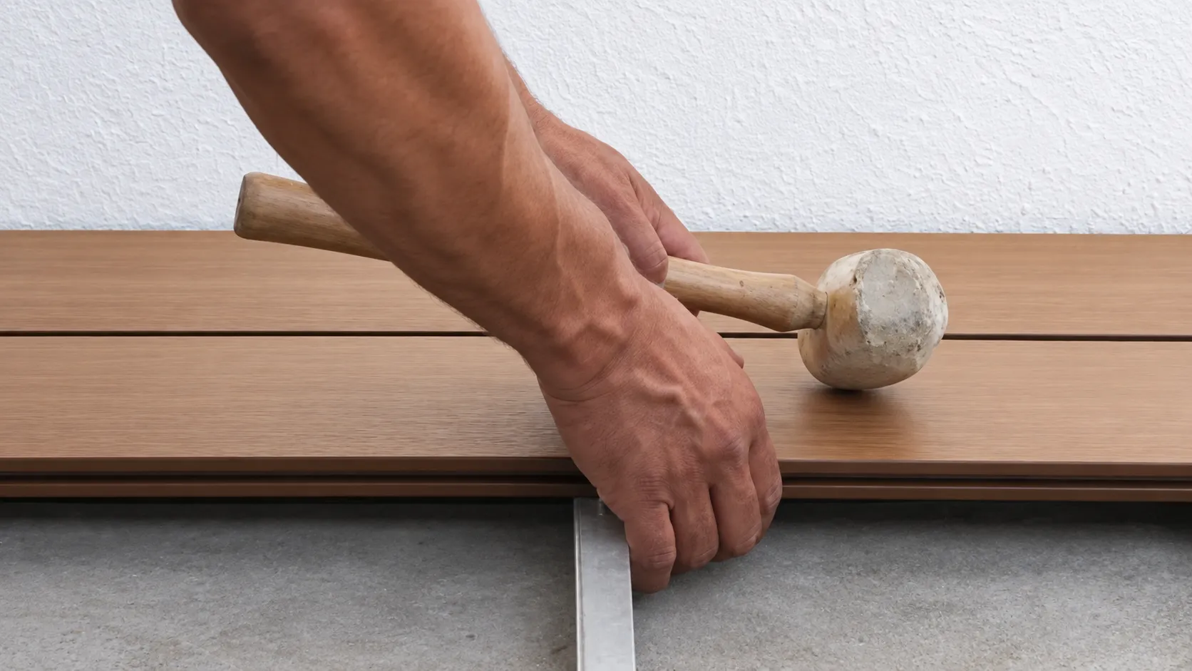 Instalador empareja con mazo de goma las tablas de deck WPC ya colocadas