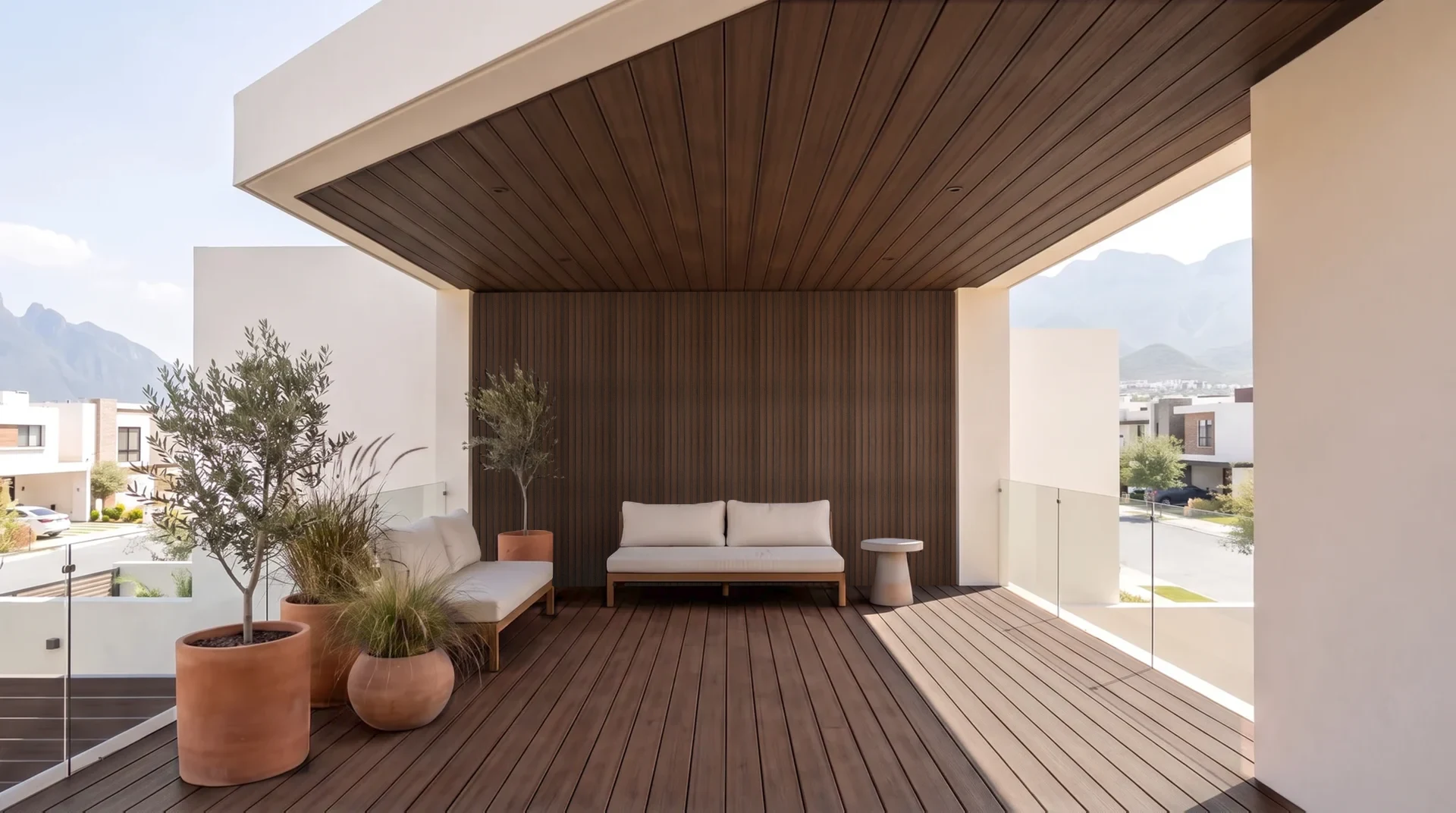 Terraza techada con el piso de deck, el muro de lambrín y el techo de plafón en color IPE